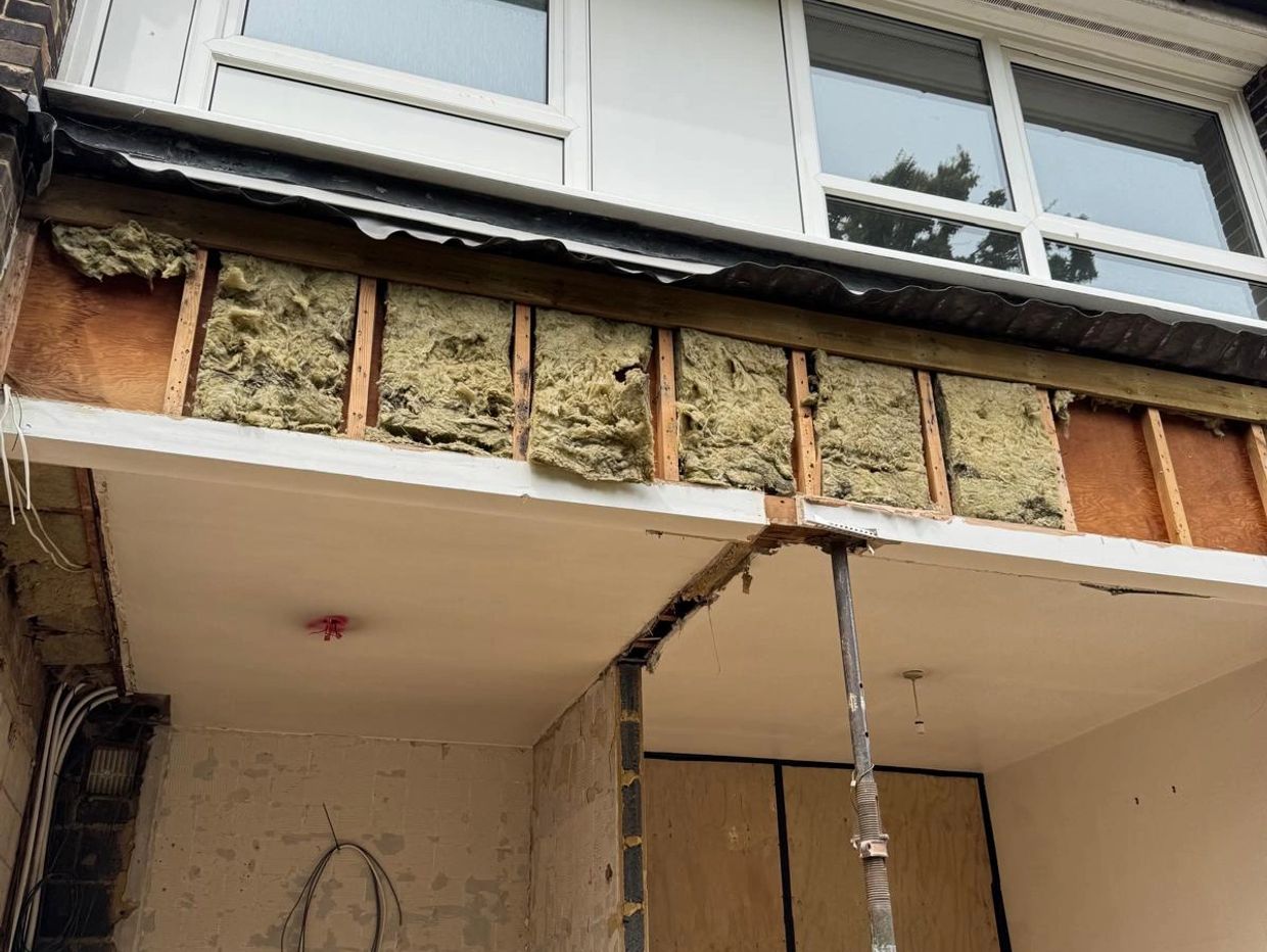 Building under renovation with exposed insulation and support beams.