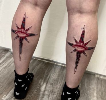 Unique tattoo of a red eye inside a compass star on the calves.