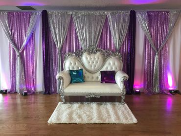 Purple and silver backdrop. Throne loveseat for party