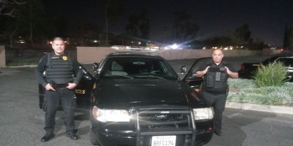 Two cops are standing near police car