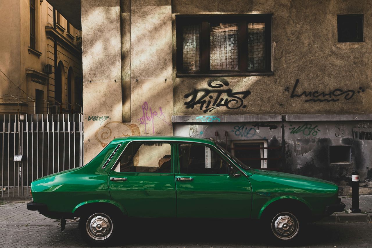 A Green Car Parked In The Shade