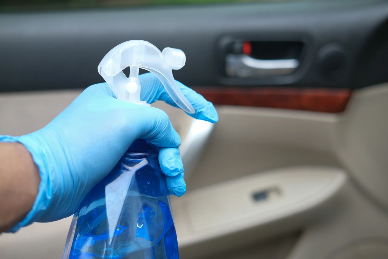 Photo of a person  applying glass cleaner to windows and mirrors for crystal-clear visibility