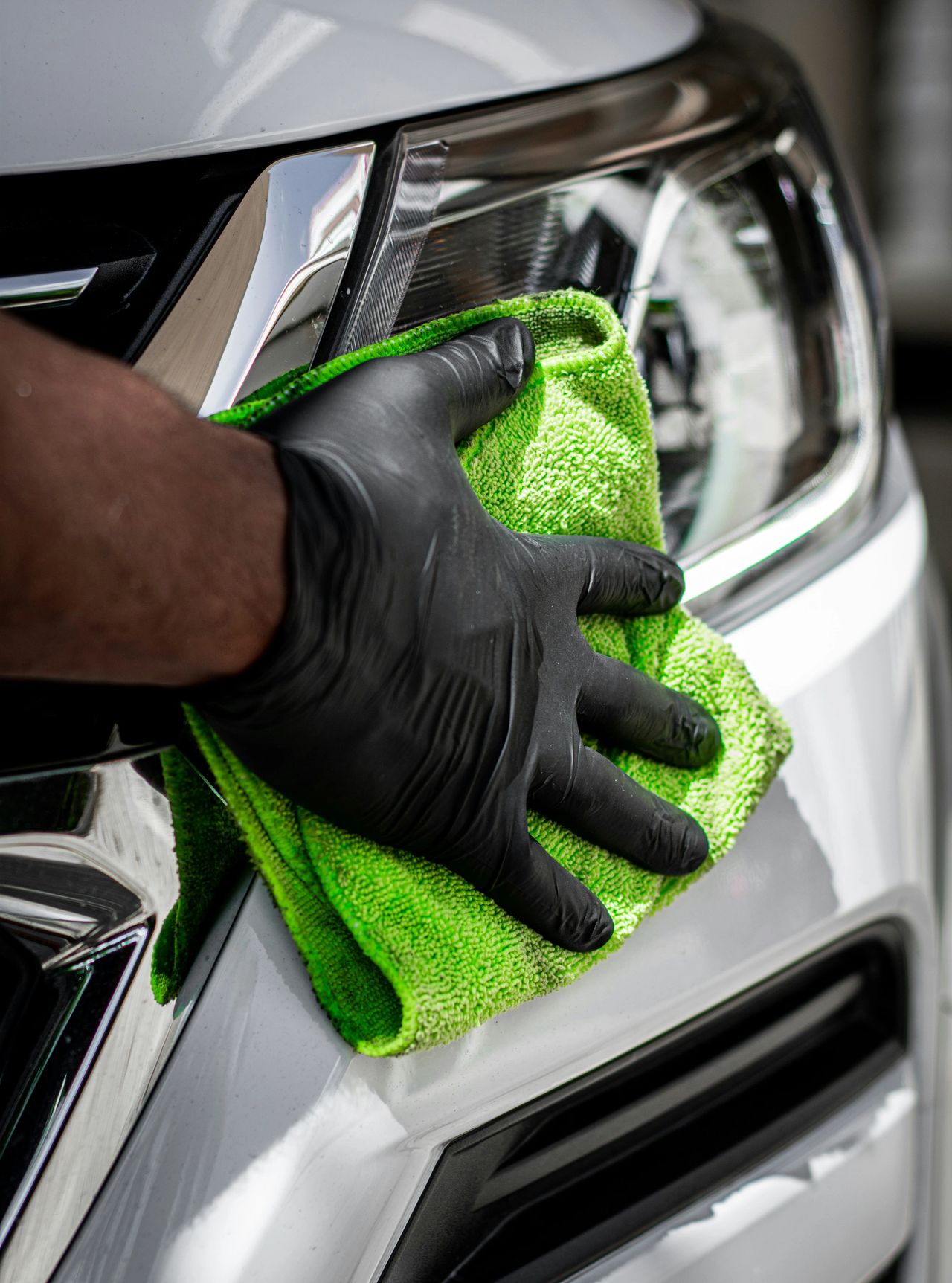 Using a clean, dry microfiber towel to remove water from a car