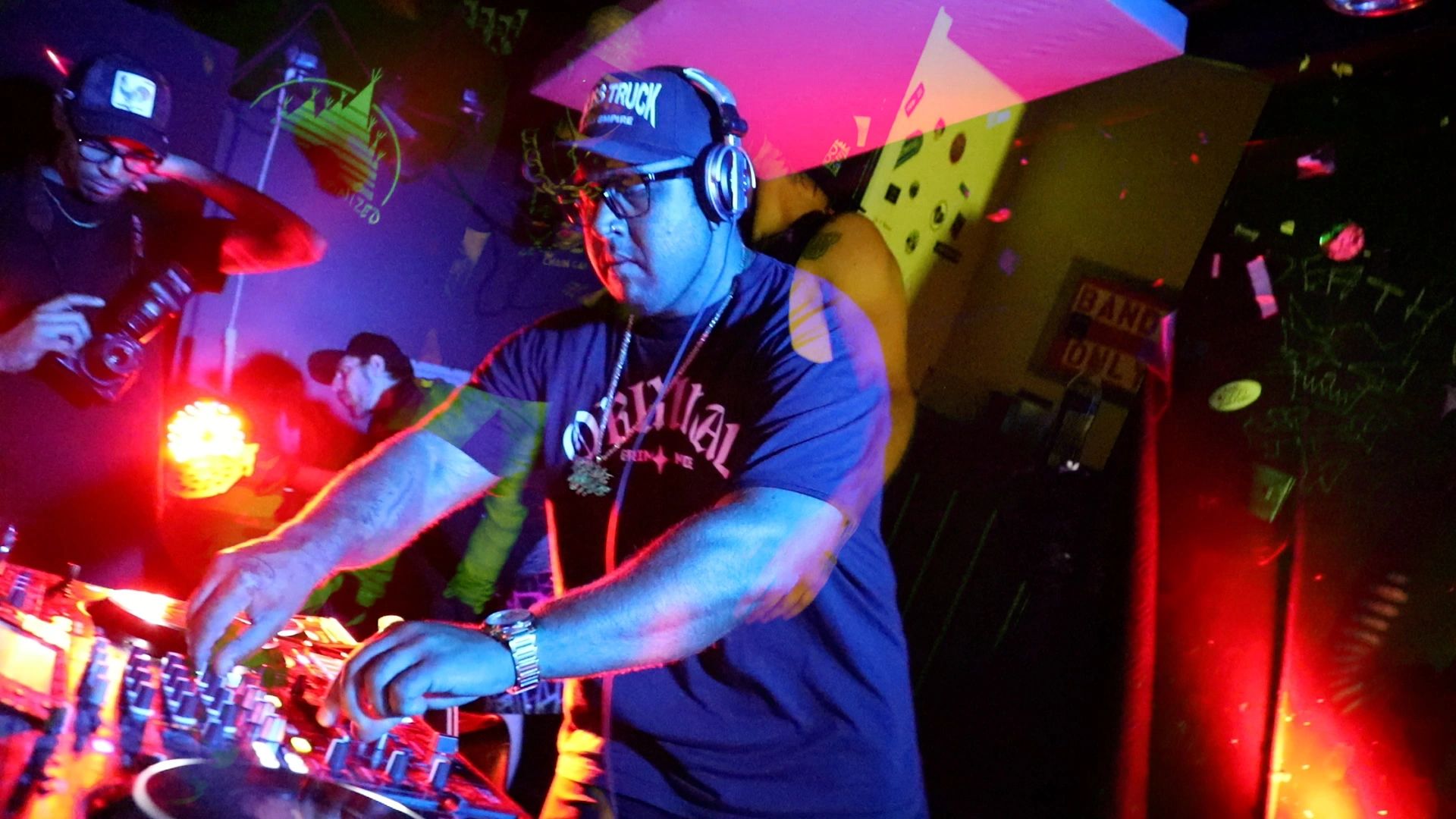 DJ mixing music at a lively, colorful nightclub event.
