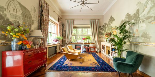 Bright, vintage living room with colorful furniture and floral decorations.