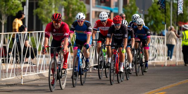 Group of cyclists racing on a city street during a competition.
