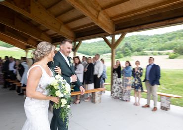 Bride and groom walking arm in arm at outdoor wedding ceremony.