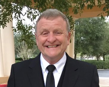 A Portrait of a Man Smiling in a Black and White Color Shirt