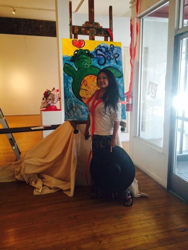 Donna K Lau with horny the whole new painting at her opening of the art gallery premiere on an easel
