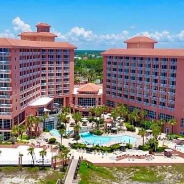Large resort with two tall buildings and central swimming pool.