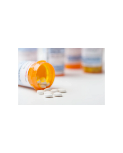 Prescription pill bottle tipped over with white tablets spilled out.