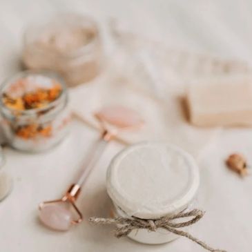 A serene skincare setup with creams, a roller, and natural elements.