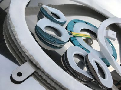 Various white and teal gaskets arranged together.
