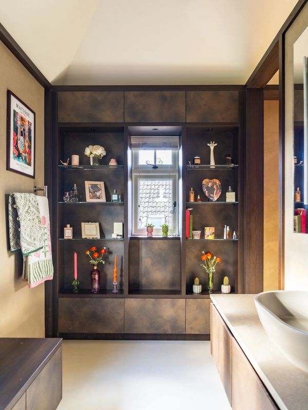 Elegant bathroom shelving with decorative items and a window at the center.