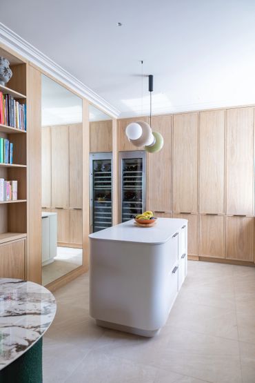 Modern kitchen with wooden cabinetry and a sleek white island.