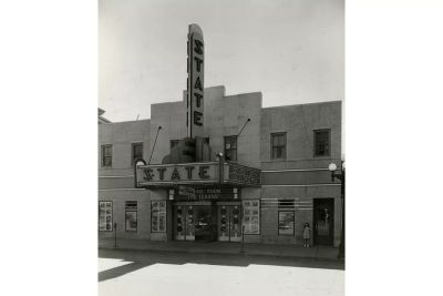 Black and white photo of the State Theatre with marquee and posters.