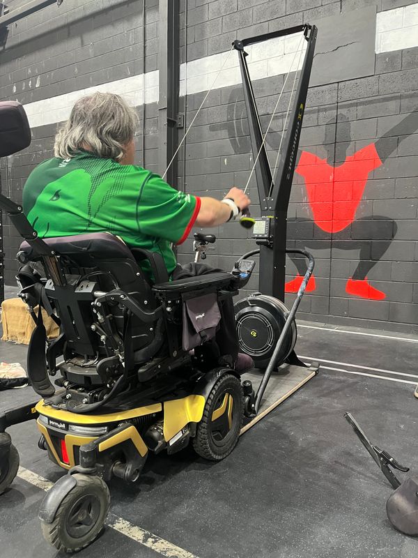 Client in powered wheelchair exercising
