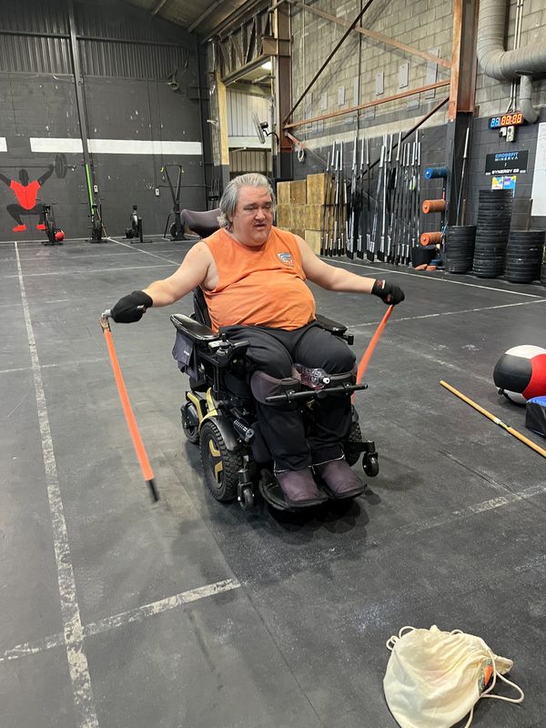 Client in powered wheelchair exercising