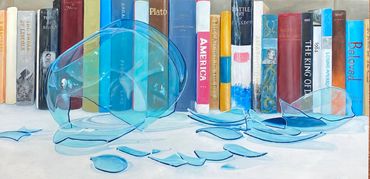 Broken blue glass in front of books on a shelf.