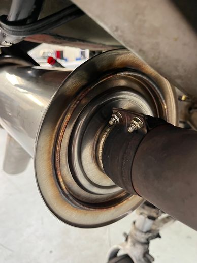 Close-up of a shiny metallic exhaust pipe connection.