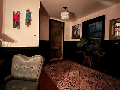 Second floor bathroom facing sauna door. Pink and black walls. sculpture and 2-d artwork. 