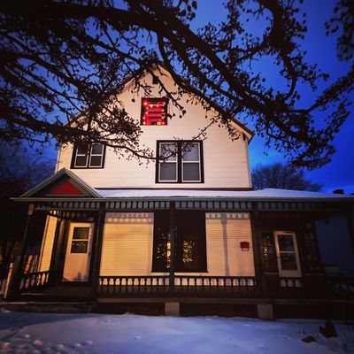 Front view of artist residency, victorian home, Christmas light in top window