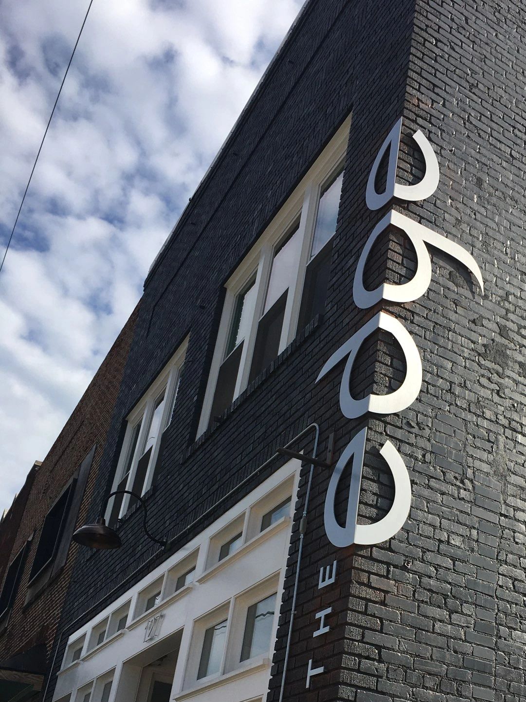 Unique custom signage installed on the corner of the edge building. 