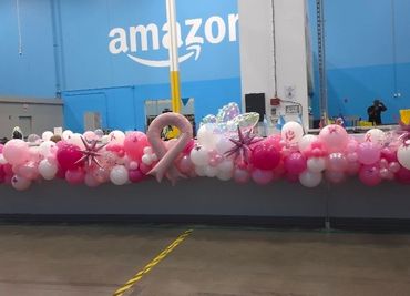 Long pink organic balloon garland on Amazon counter for breast cancer awareness