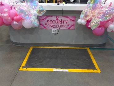 Pink balloon garland on security desk for breast cancer awareness event