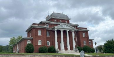 Historic red brick courthouse with white columns.