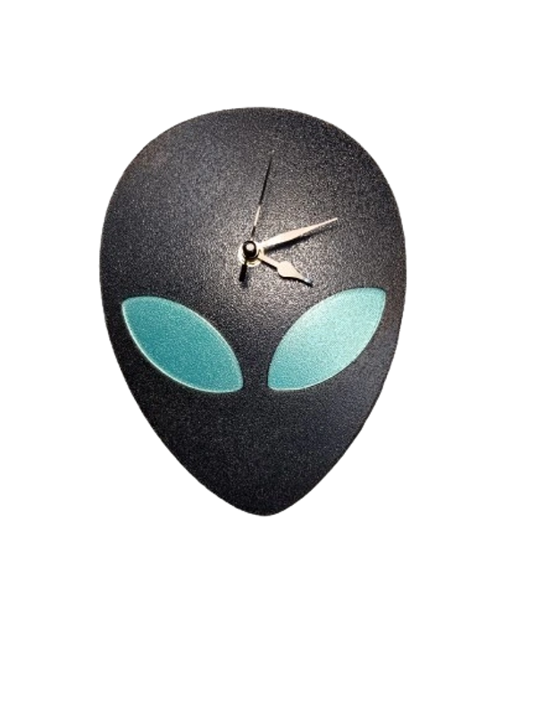 A clock with an alien face. Black with green eyes.