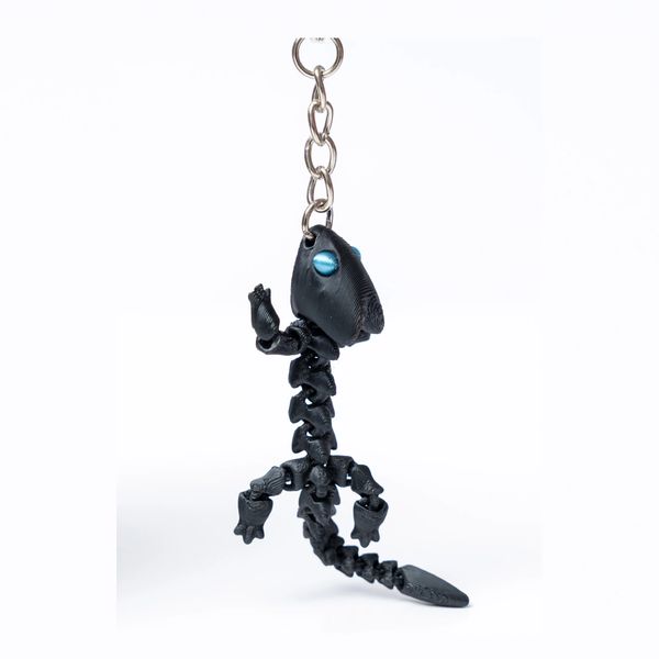 A keyring with a smooth black Arrowhead dragon attached.