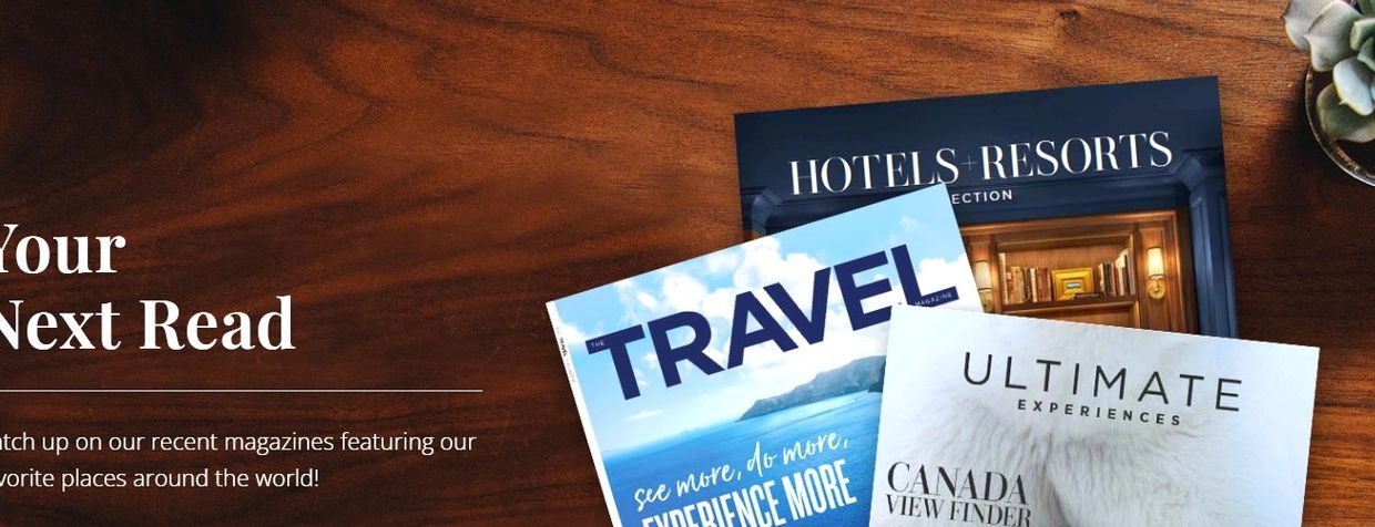 Stack of travel and lifestyle magazines on a wooden table.
