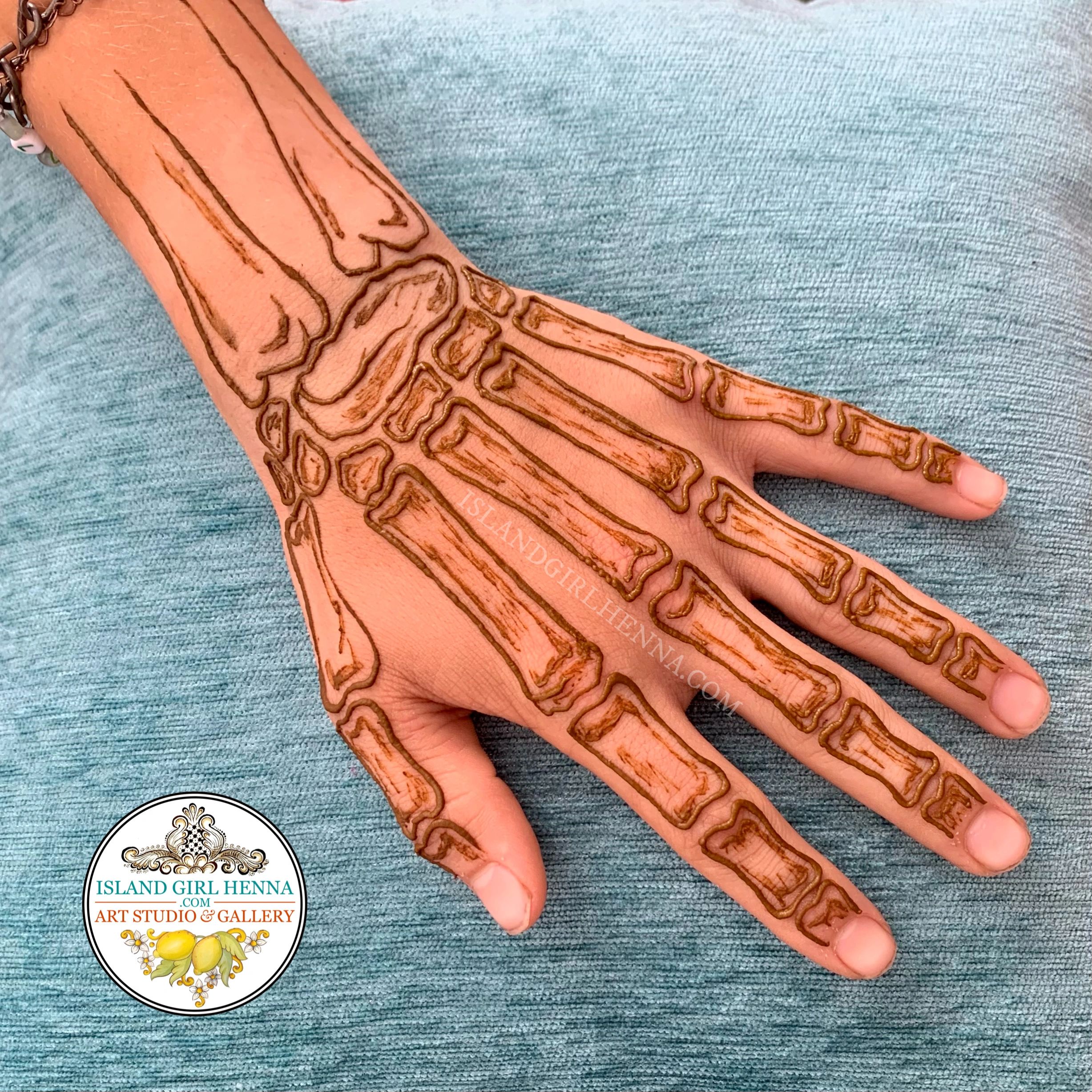 Henna design resembling hand bones on the back of a hand.