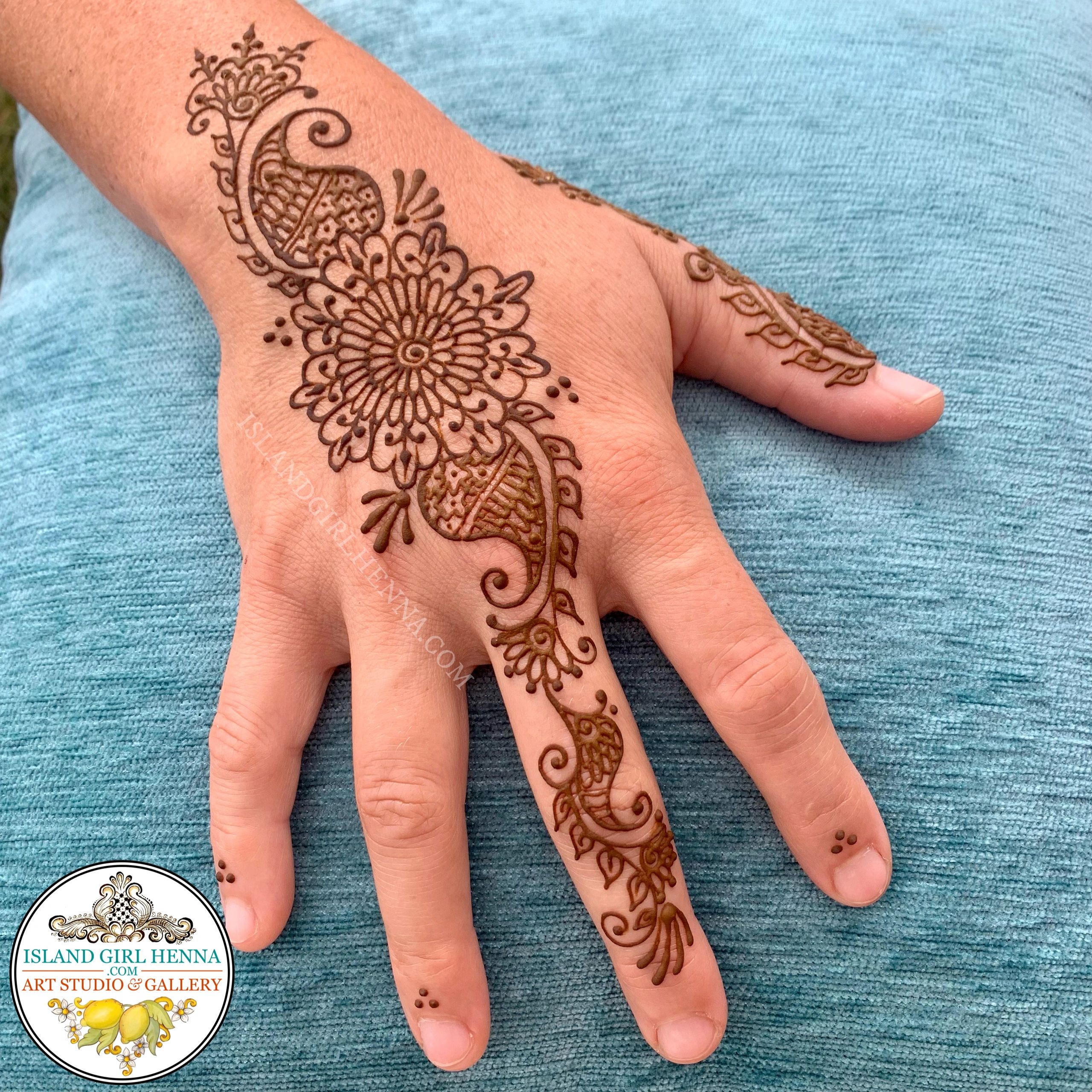 Intricate henna design with floral and paisley patterns on a hand.