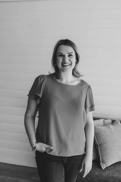 Smiling woman standing with relaxed posture indoors.