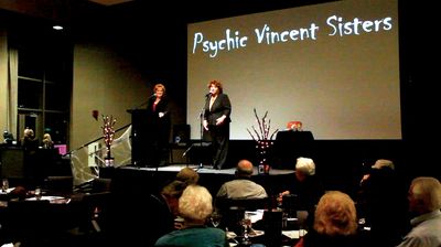 Two women on stage performing for an audience.