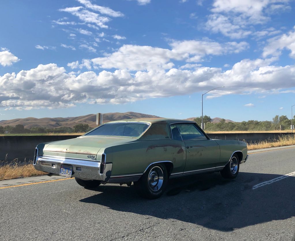 Classic green Chevrolet Monte Carlo on a sunny road.
