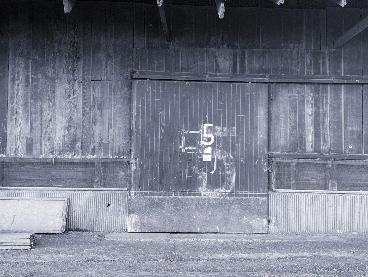 Old wooden barn door with the number 5.