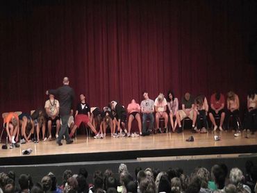 People on stage appear to be hypnotized during a show.