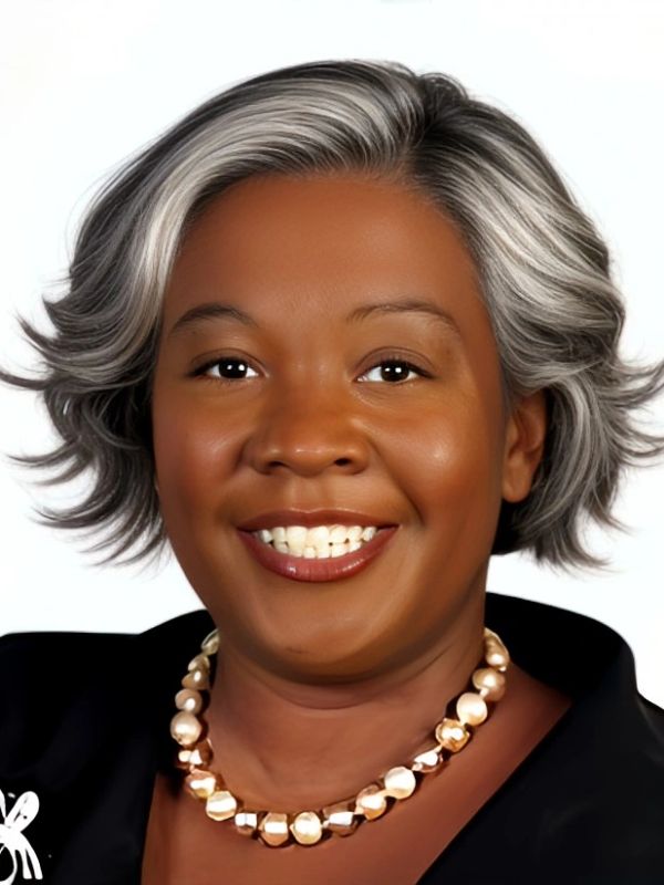 Smiling woman with short gray hair and pearl necklace.