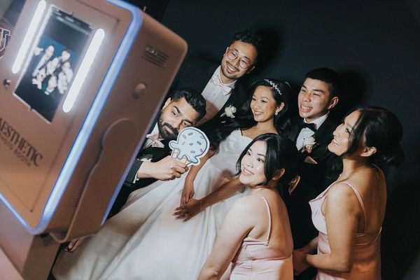 Bride, groom and wedding party guest  using photo booth. Image by Silas Chau