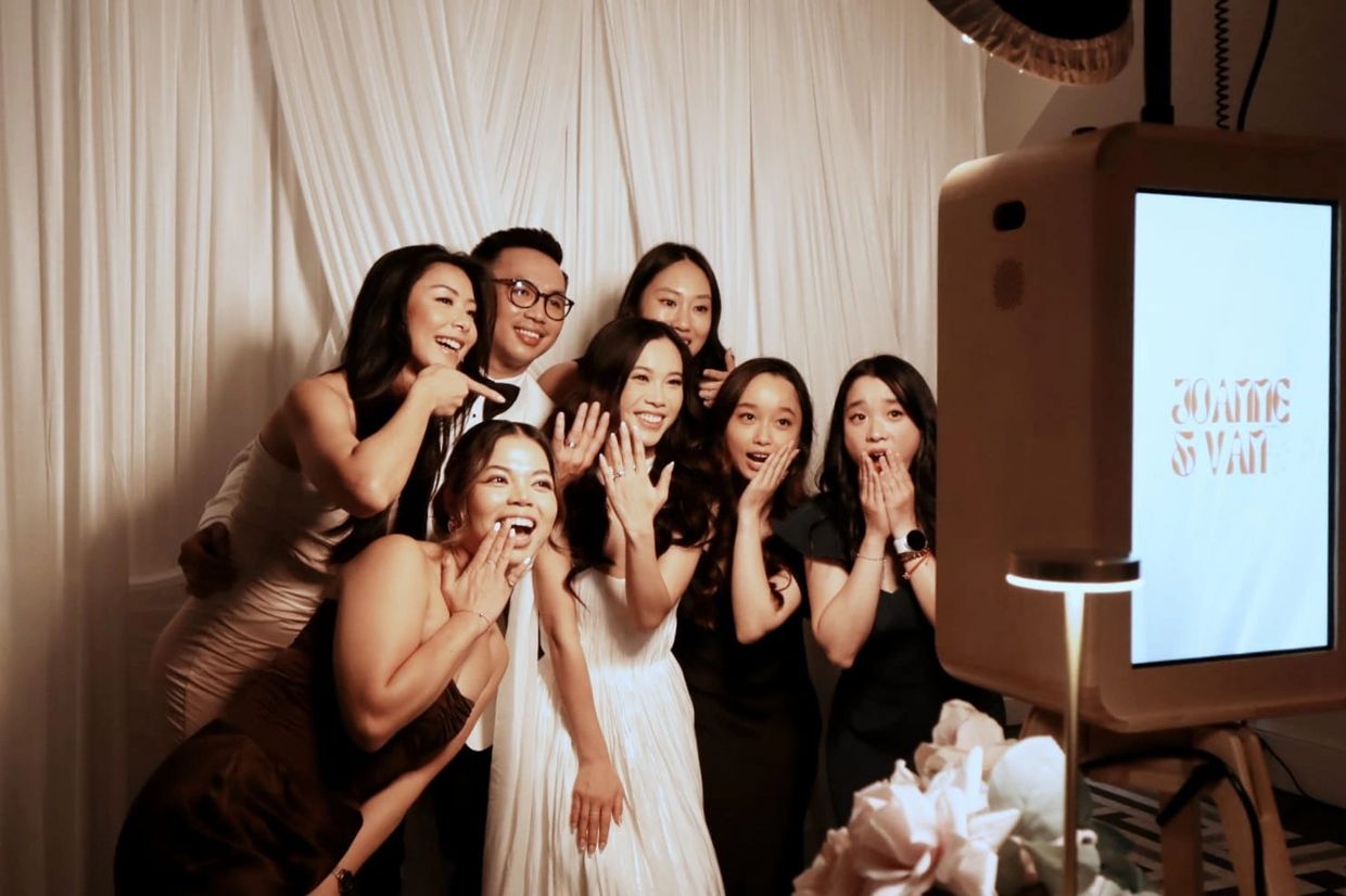 A joyful group taking a photo in a photo booth at an event.