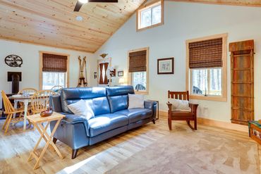 Cozy cabin interior with wood plank floors and blue sofa