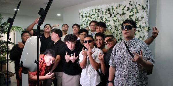 Group of young men posing for a photo with playful hand gestures.