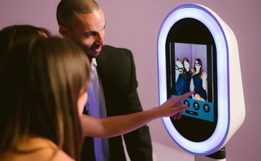 People interacting with a digital photo booth at an event.