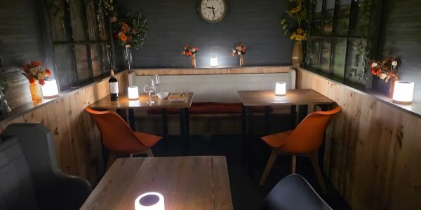 Cozy restaurant corner with warm lighting and orange chairs.