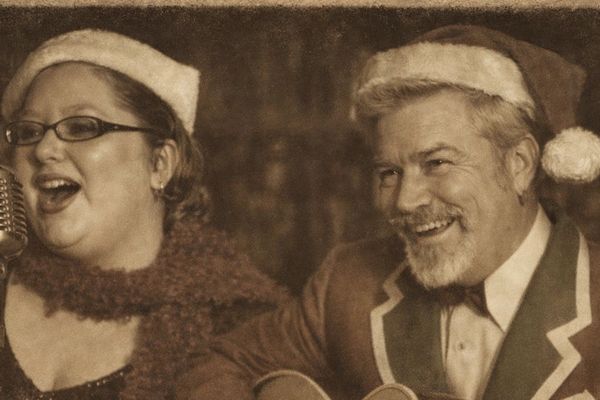 Vintage photo of a festive duo singing and playing guitar.