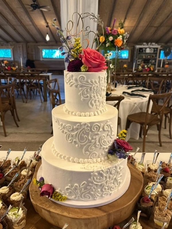 Beautifully decorated white wedding cake topped with flowers