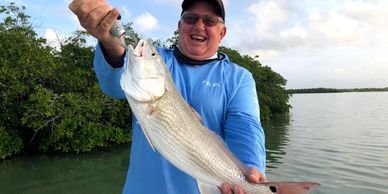 Key Largo inshore fishing charters. Man catching a redfish